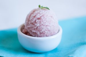 Uma bola de sorvete de melancia com uma folha de manjericão por PratoFundo.com